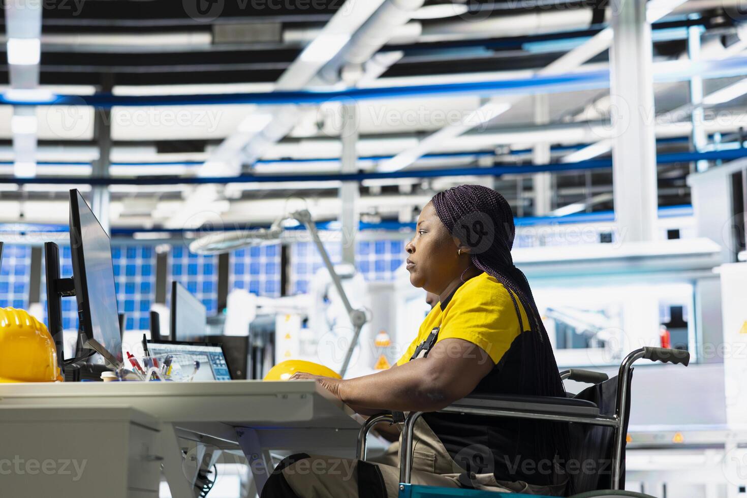 Woman with disability works in industrial factory on designing solar cells, debugging and fixing malfunctioning systems. Engineer wheelchair user ensuring operational reliability at power plant. photo