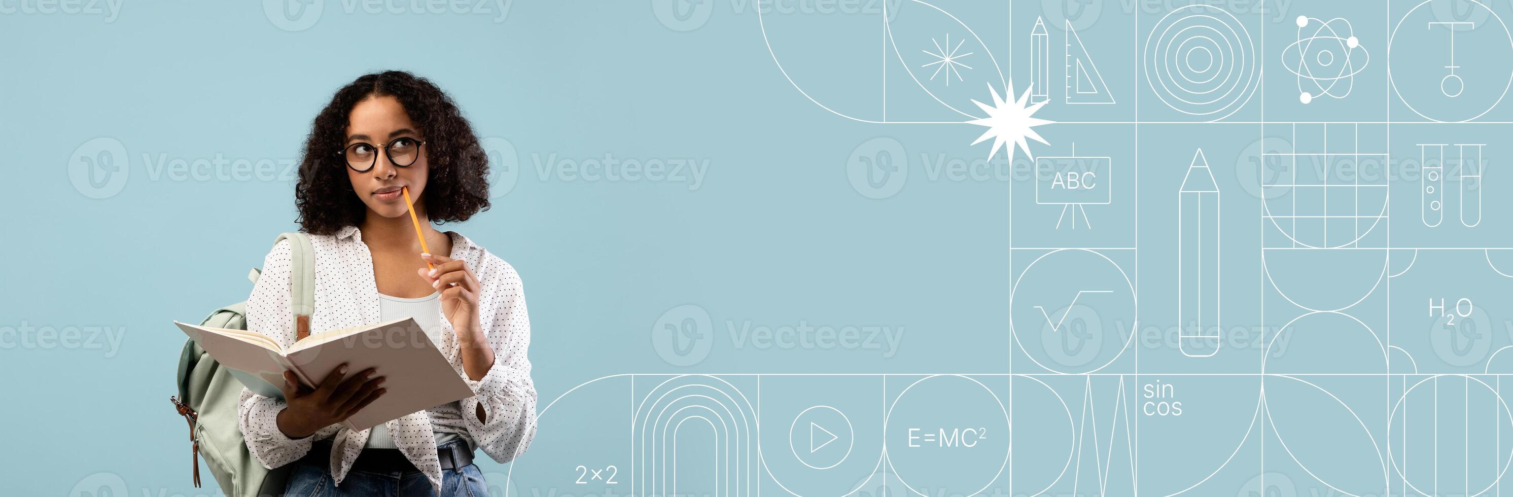 A student is deep in thought while studying with a notebook in one hand and touching her chin with the other. photo