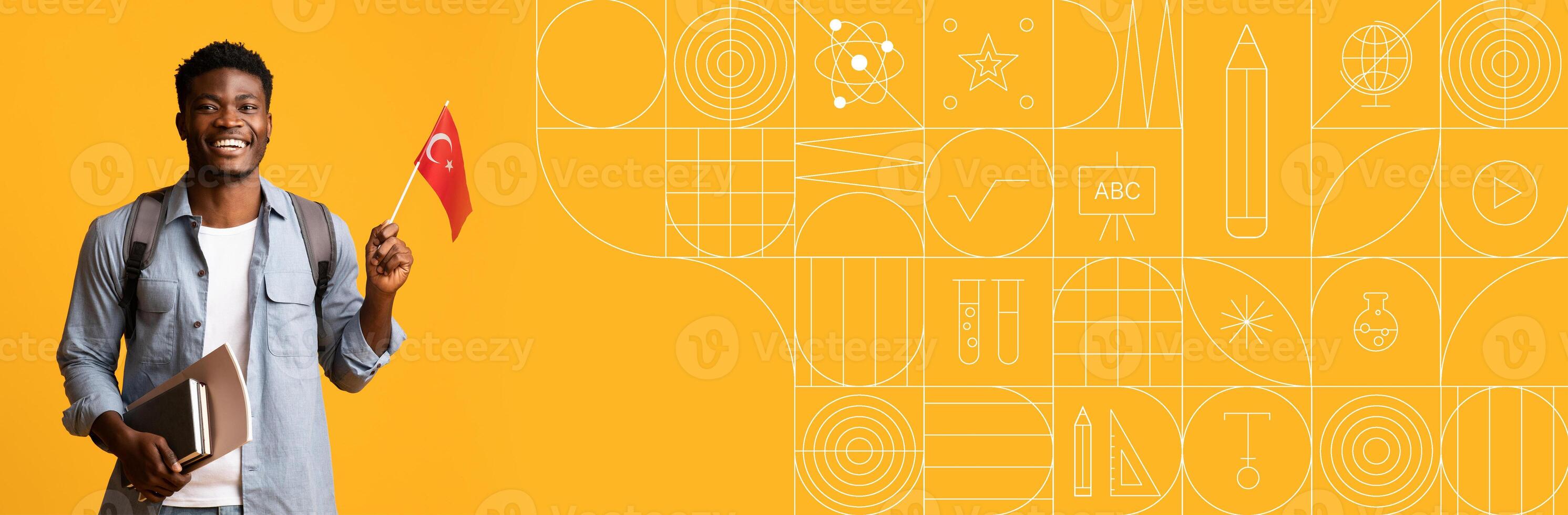 A joyful student holds a flag while standing with books in front of a colorful painted background. The vibrant scene captures the enthusiasm for learning and cultural pride. photo