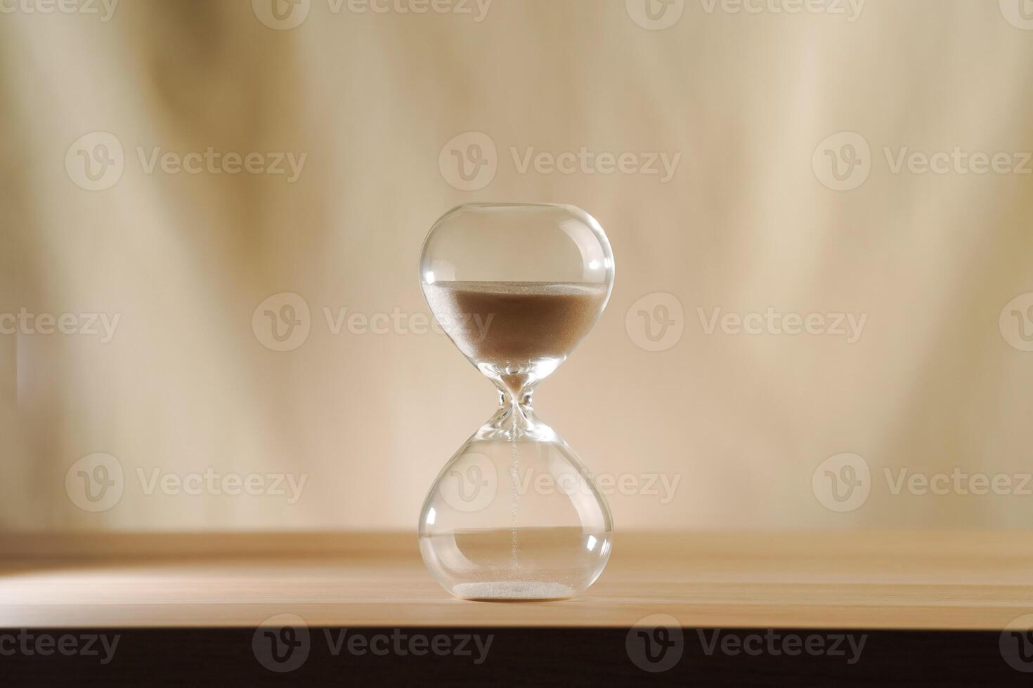 A simple hourglass on a wooden table with a beige backdrop, symbolizing time flow and minimalistic living. Represents plenty of time, uncluttered presentation for stylish concepts. photo