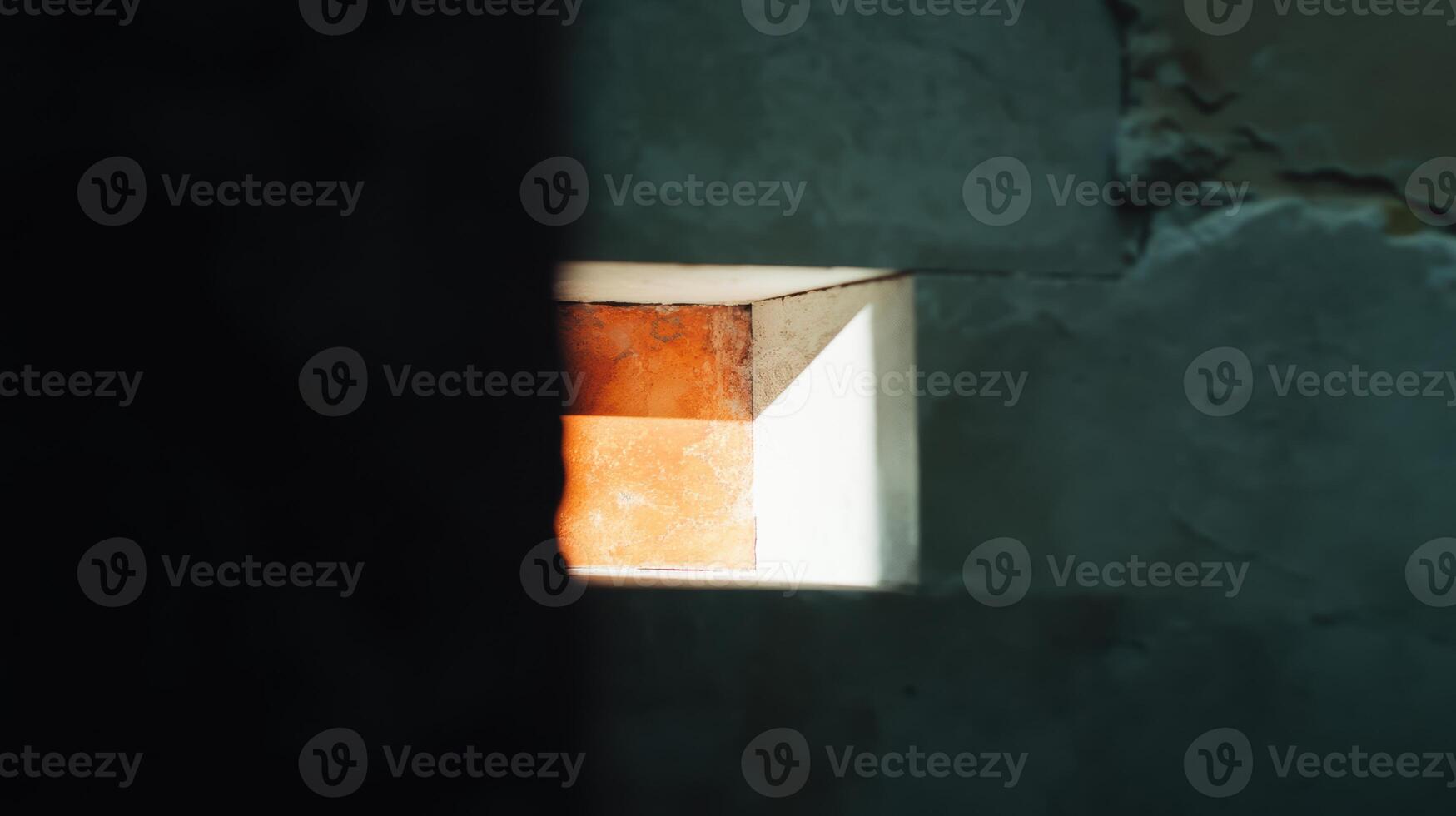 Lighting effect seen through a wall opening in a rustic setting photo