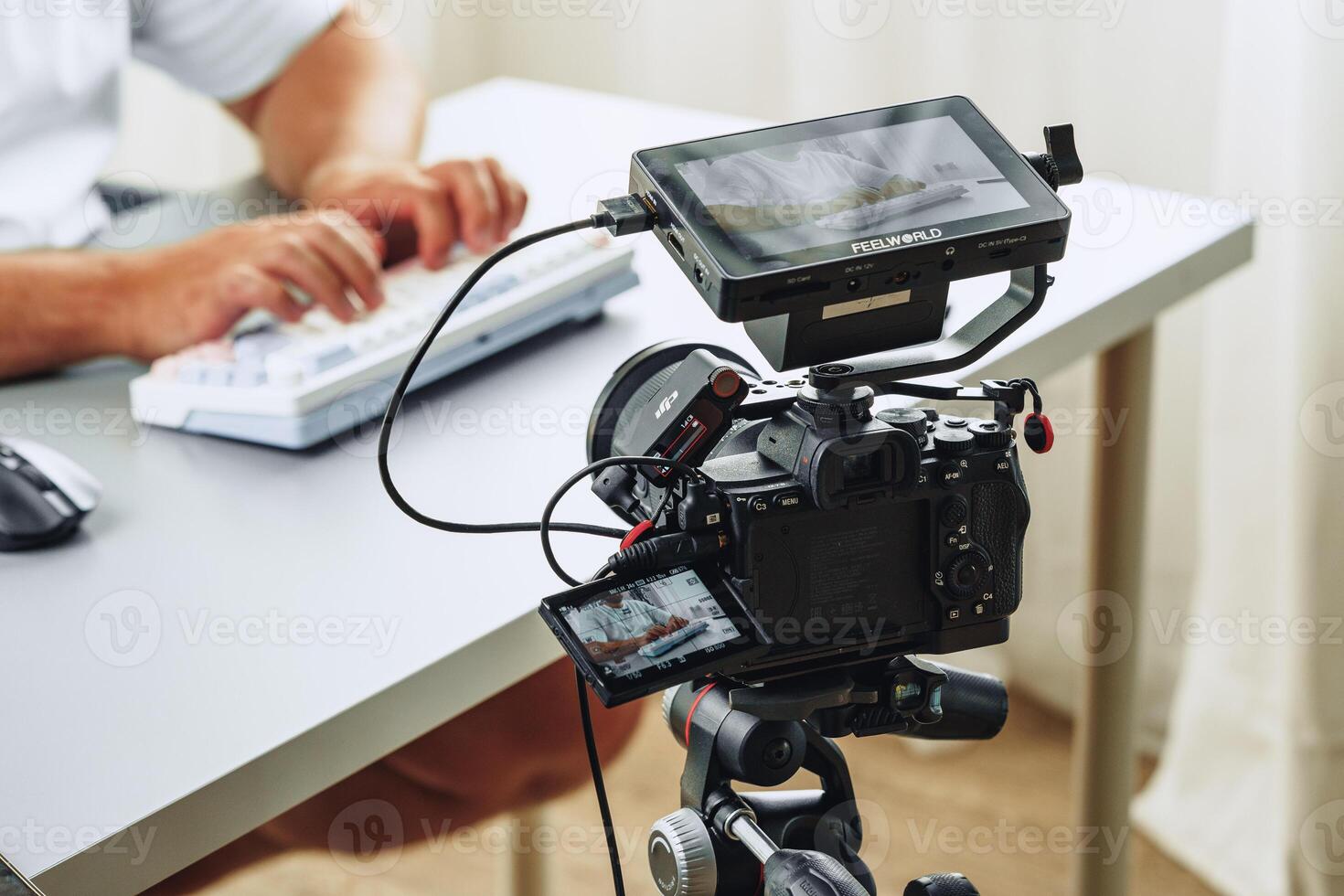 Filming a tutorial at a modern workspace with advanced camera setup and keyboard use photo