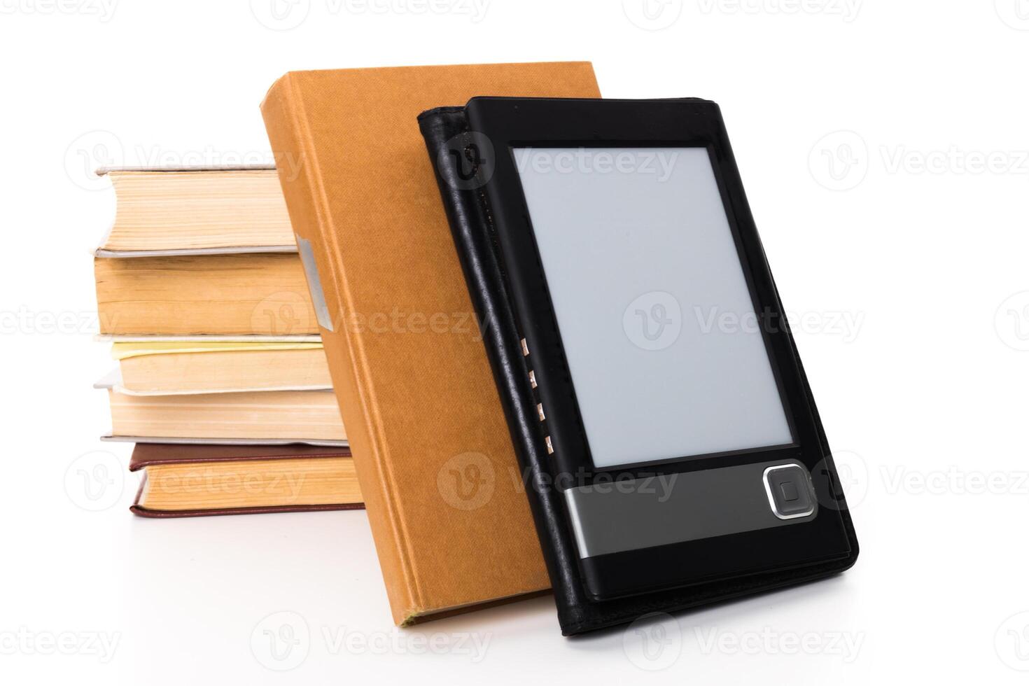 E-reader resting beside a stack of books on a white background in a home setting photo