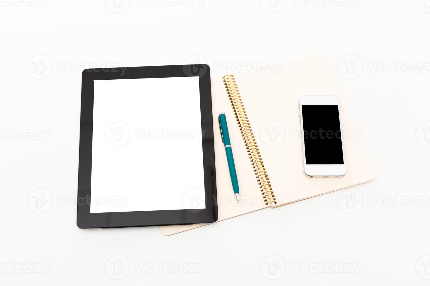 Workspace setup with tablet, notebook, pen, and smartphone displayed on white background photo