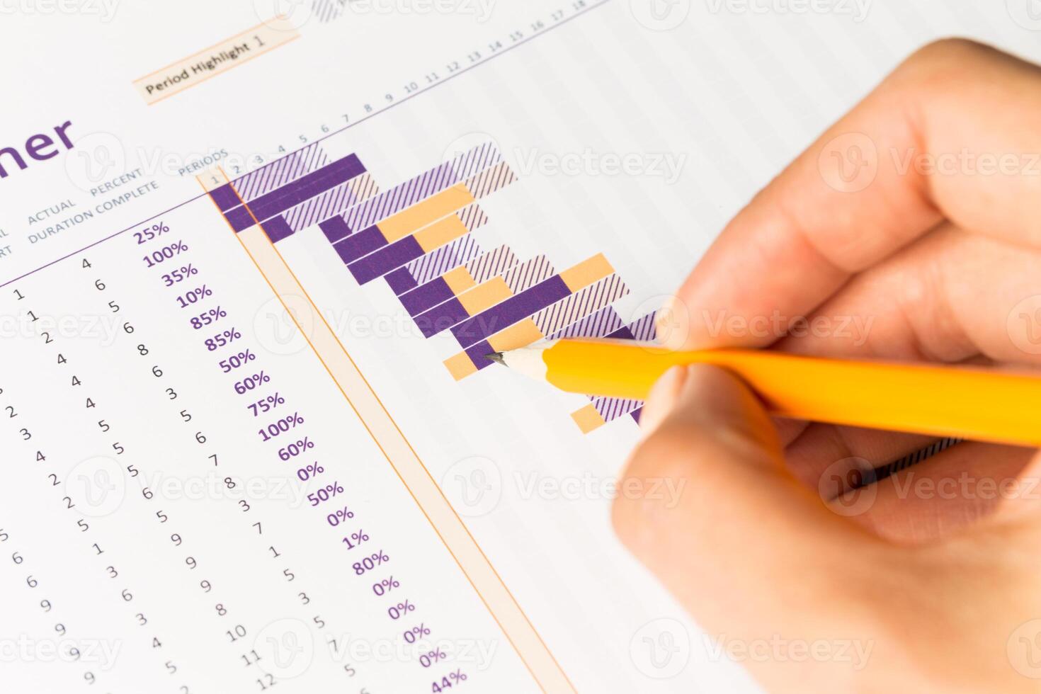 Detailed project planning visualization displayed in a chart with hand marking progress photo