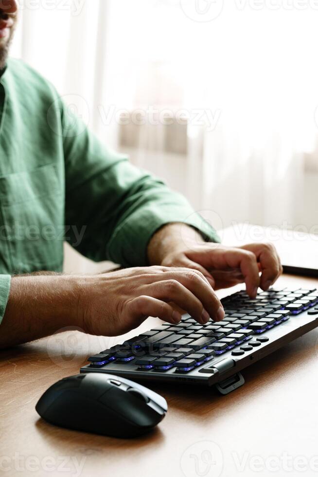 Person working on a keyboard while using a computer mouse in a well-lit room photo