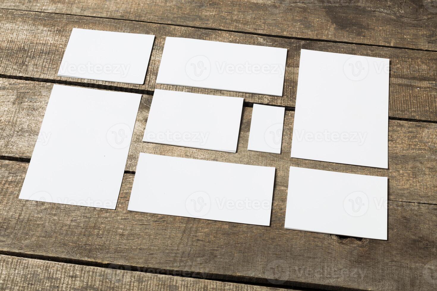 Various blank sheets of paper arranged on a rustic wooden table for creative projects photo
