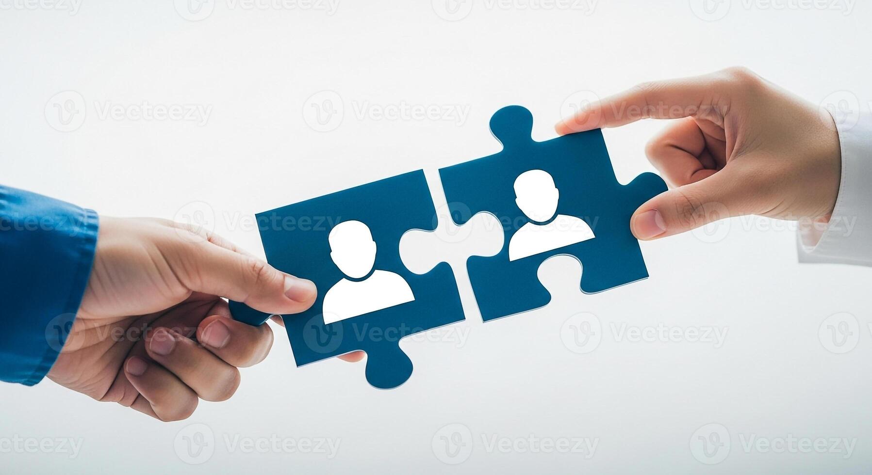 Two hands connecting two puzzle pieces with people icons symbolizing partnership teamwork and collaboration in a modern business setting This image represents the concept of unity connection and mergi photo