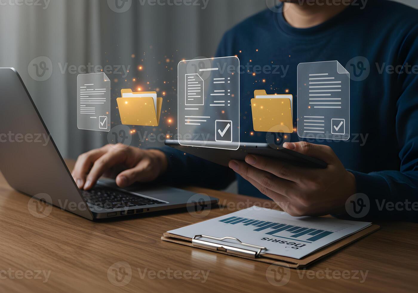 Man working on laptop and tablet managing digital documents and files in a modern office showcasing efficient workflow and data organization photo