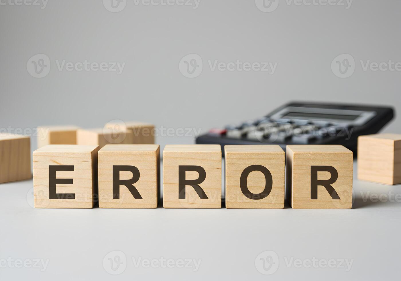 Wooden cubes spelling ERROR on a table near a calculator depicting a mistake fault or an error in calculation or system conveying a sense of problem troubleshooting and technical issue photo