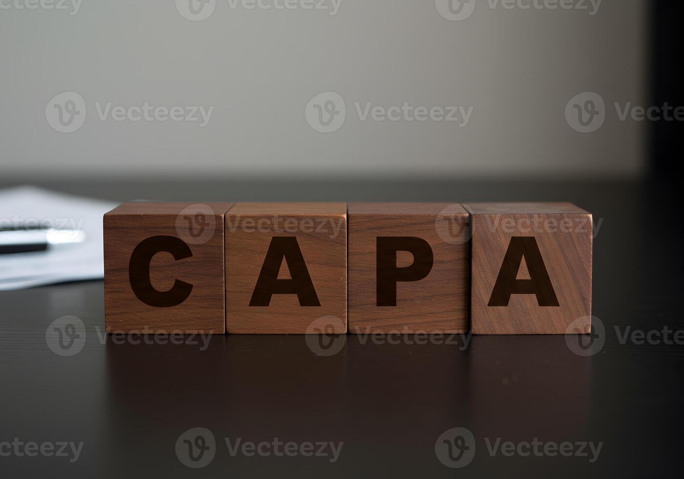 Wooden blocks spelling out CAPA on a dark desk signifying Corrective Action Preventive Action in business and quality management The concept evokes themes of process improvement and risk mitigation id photo