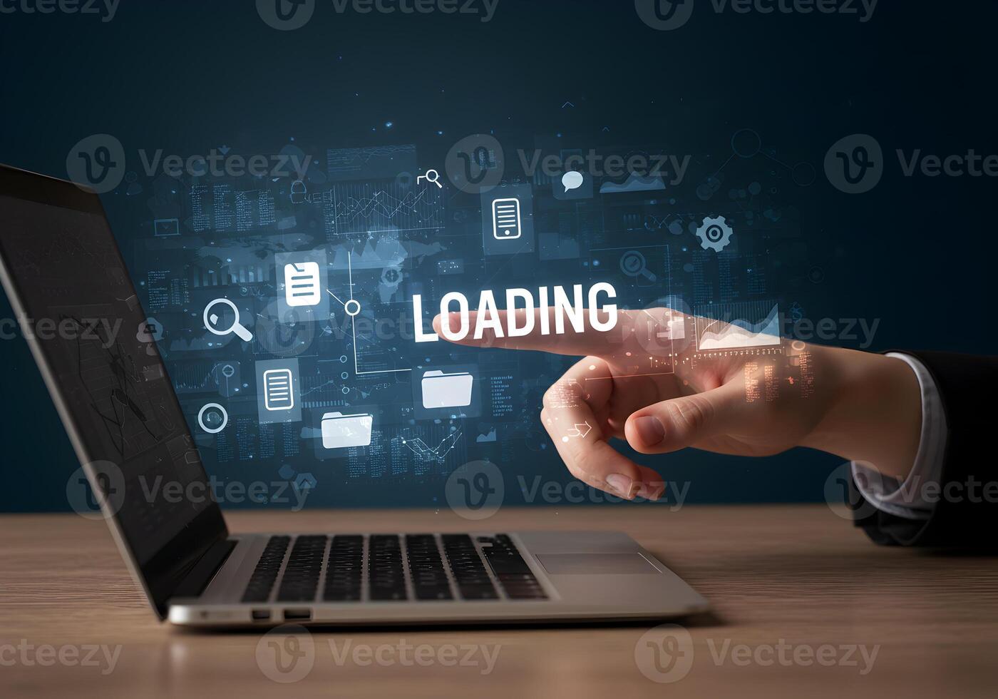 Hand interacting with a laptop screen displaying the word LOADING surrounded by digital icons and data representing the concept of progress and anticipation in a modern technological setting photo