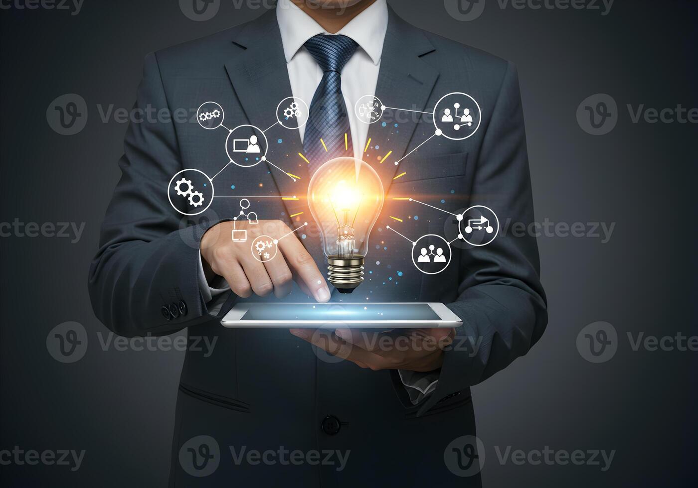 Businessman activating a glowing lightbulb idea on a digital tablet symbolizing innovation connection and teamwork in a modern business setting This image represents creativity collaboration and strat photo