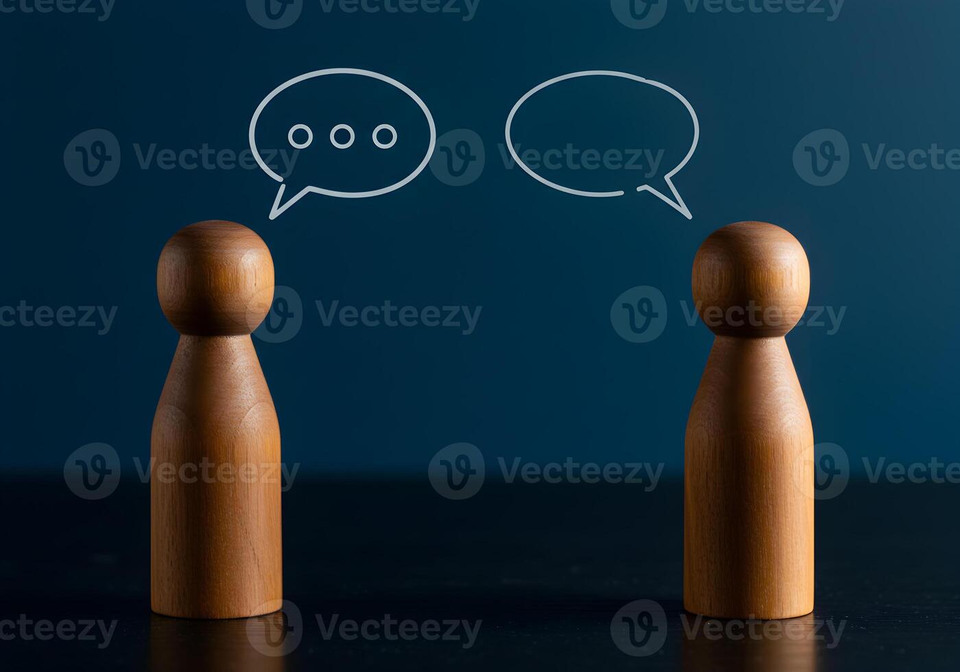 Wooden figures communicating via speech bubbles on a dark background symbolizing dialogue conversation and interpersonal communication photo