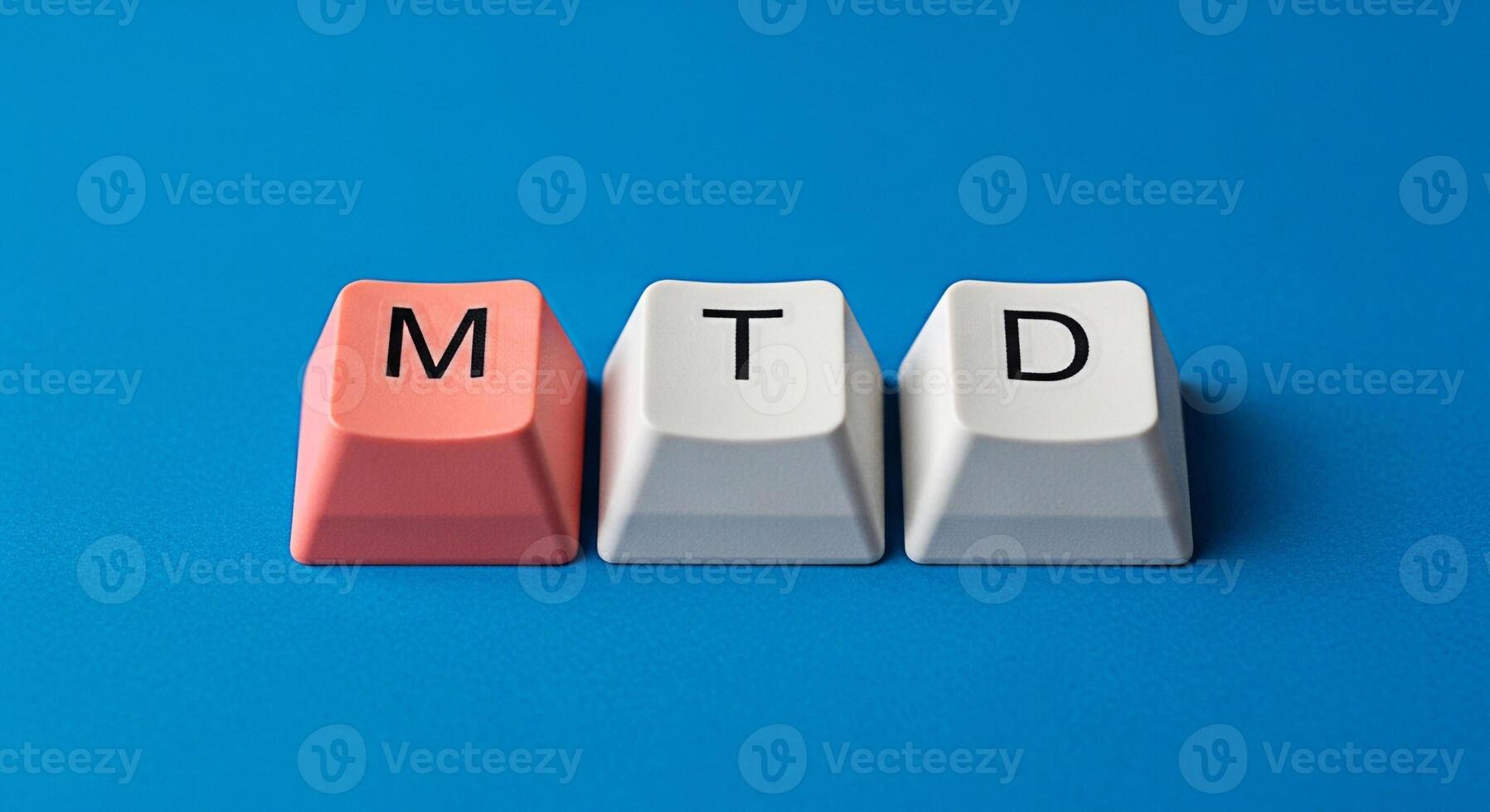 MTD letters displayed on keyboard keys against a blue background representing month to date concept photo