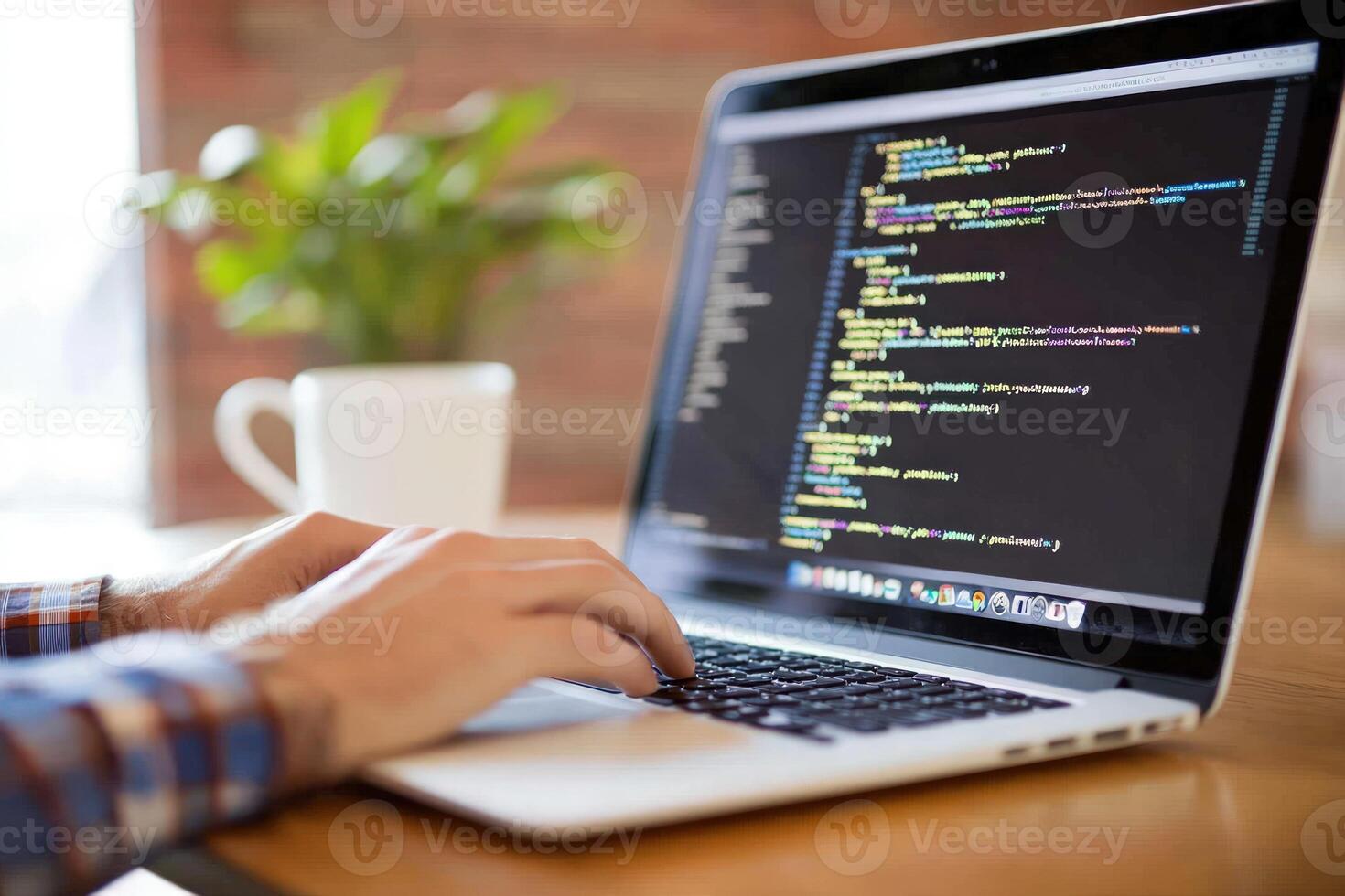 Laptop screen displays programming code with person typing photo