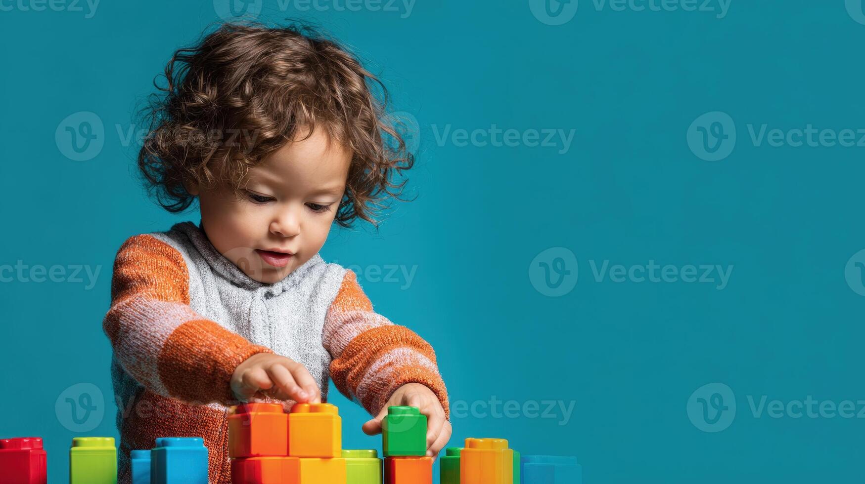 A cheerful toddler builds with colorful blocks, enjoying creative playtime and learning. photo