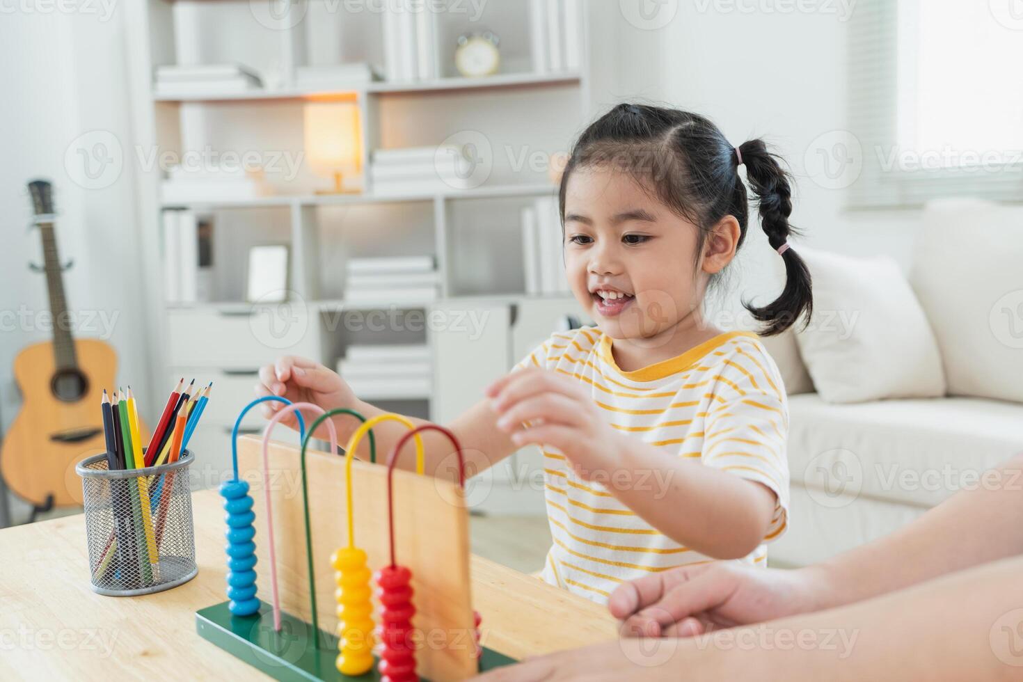 Happy child learning with colorful counting beads in bright, modern room, engaging in educational playtime, developing fine motor skills and creativity photo