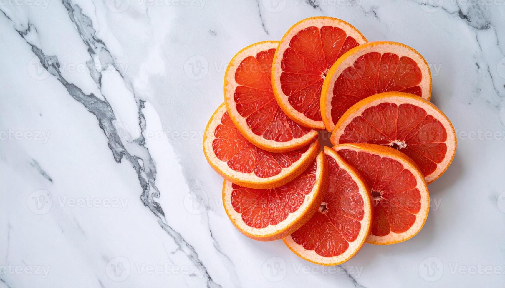 Grapefruit quarters forming a pinwheel on cool marble with thin reflected edges fresh citrus still life for editorial beverage menus and clean design photo
