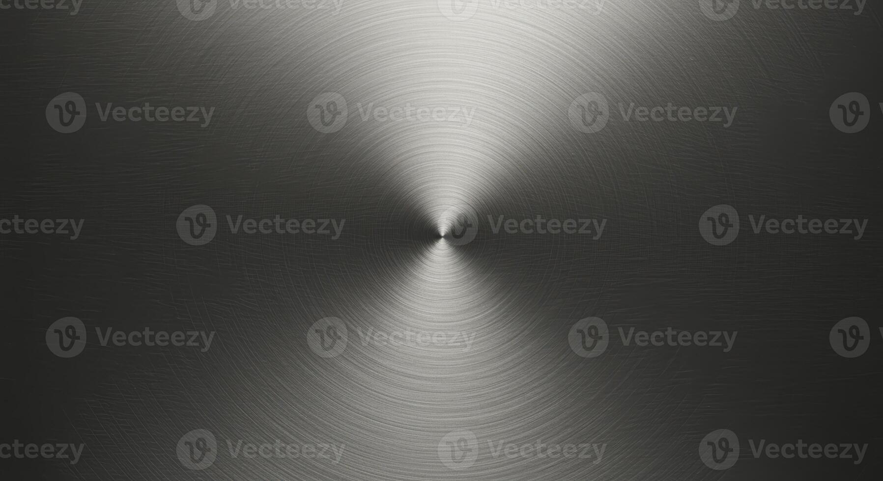 The circular brushed metal texture reflects a central light source, creating a modern and industrial aesthetic with subtle gradients in shades of gray and silver. photo