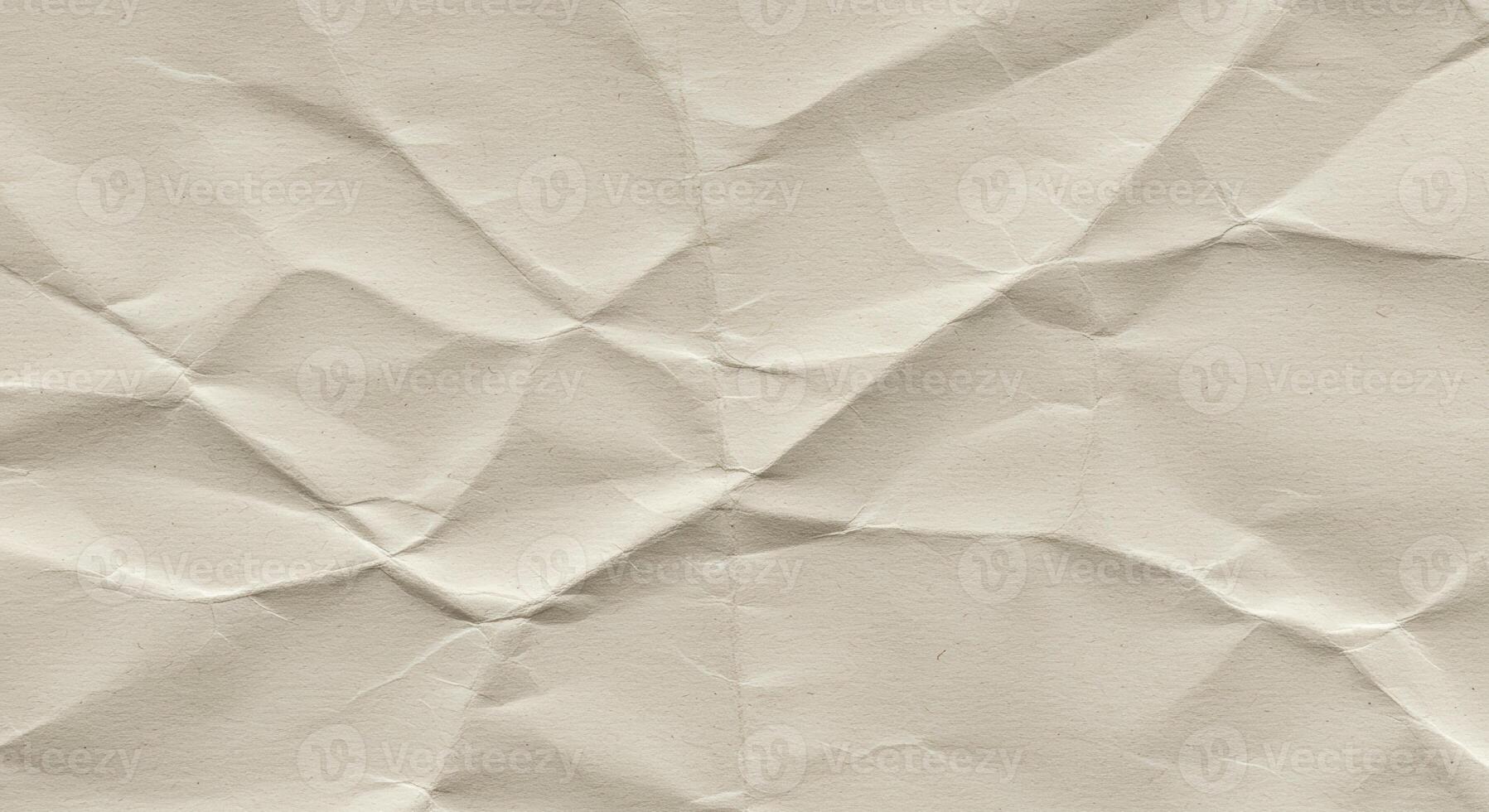 The detailed texture of the crumpled cream colored paper reveals geometric patterns and highlights the unique surface of the wrinkled sheet after being crushed up. photo