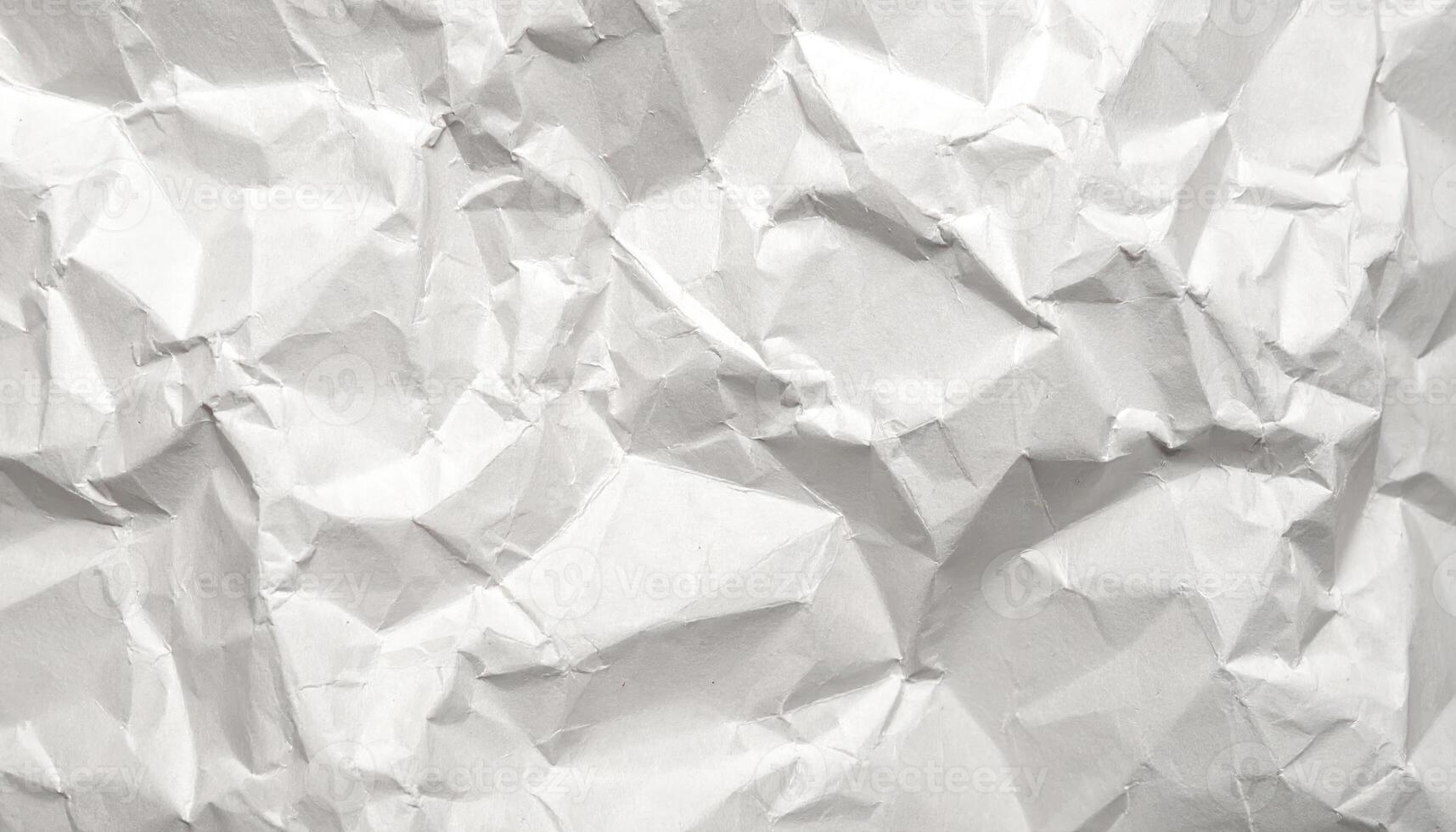 The abstract texture of crumpled white paper creates a rough and irregular surface, showcasing a dynamic interplay of light and shadow for a unique look. photo