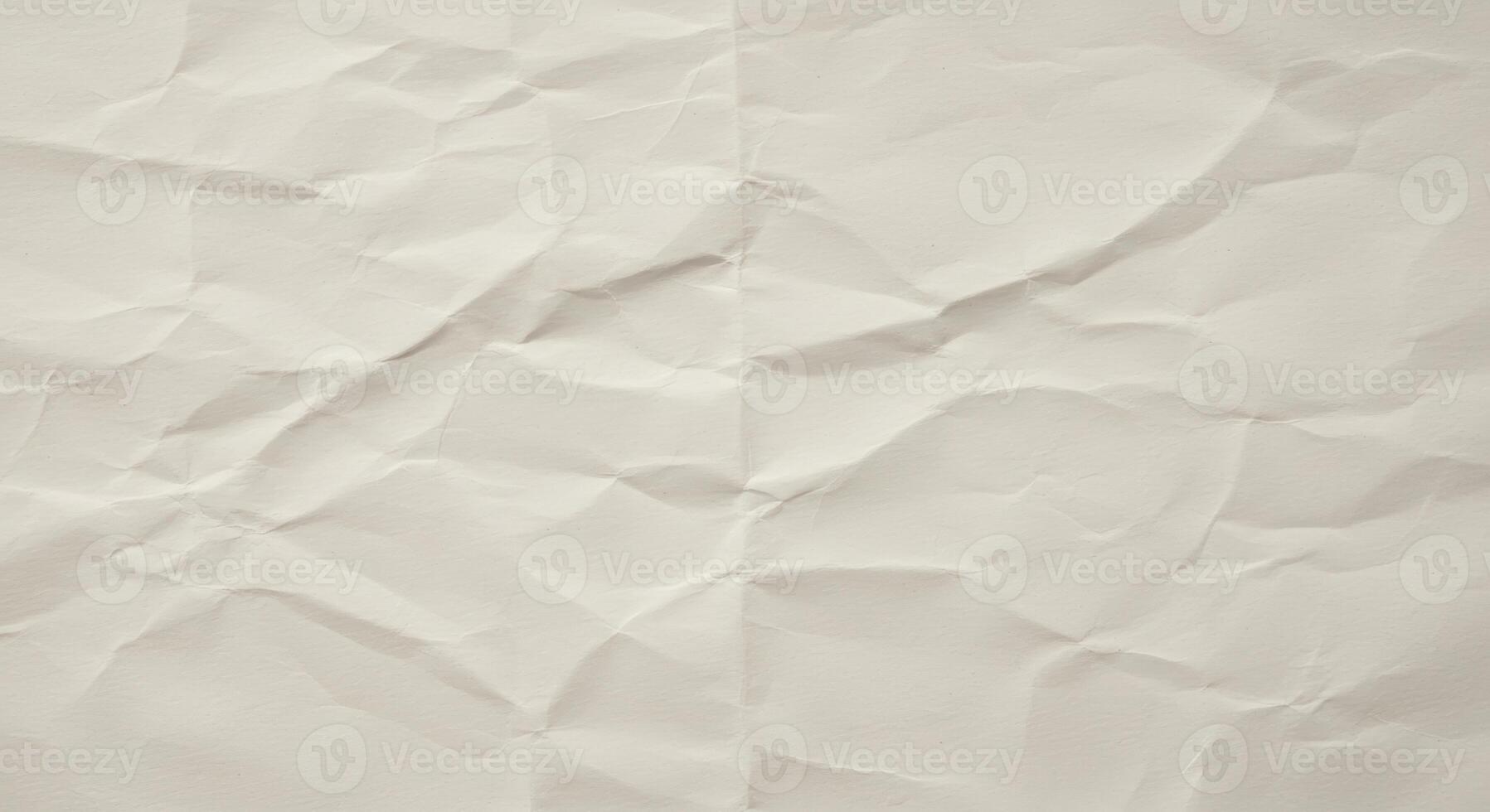Close up of slightly crumpled beige paper revealing textures and shadows creating an abstract background perfect for laye and artistic design projects. photo