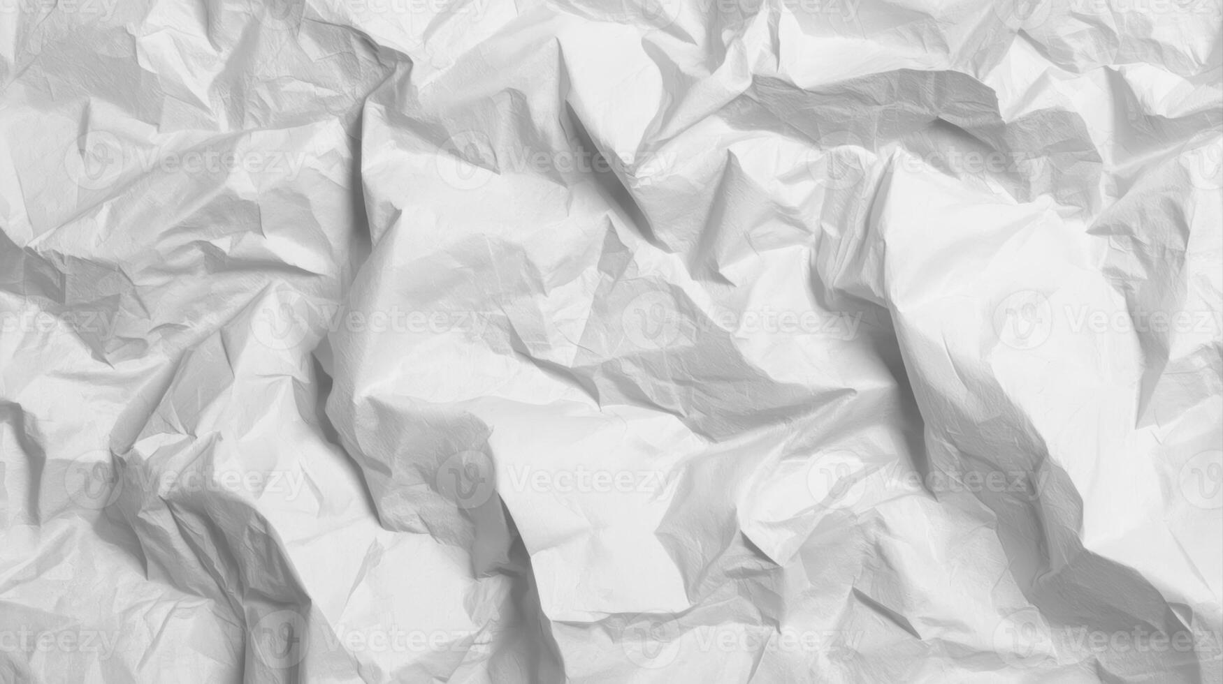 Heavily crumpled white paper shows intense creases and folds, creating a textured abstract surface perfect for backgrounds and designs needing a rough feel. photo