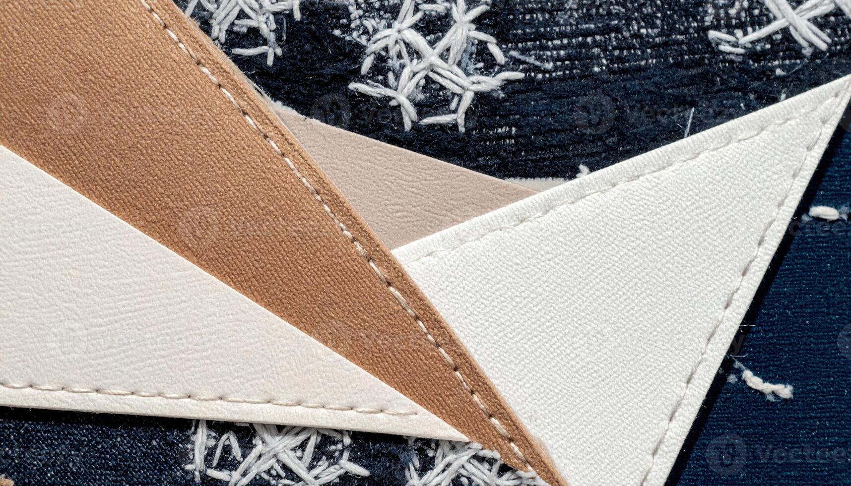 Macro view showcases geometric textile patterns and overlapping textures in neutral and navy hues, emphasizing craftsmanship and detailed stitching on various materials. photo