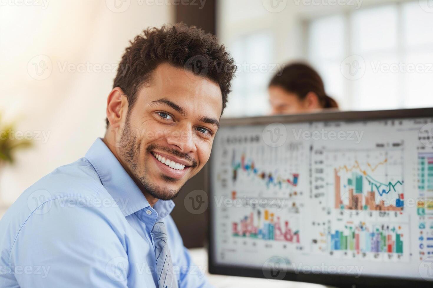 Portrait of happy financial broker is smiling in front of a computer monitor with charts in office. photo