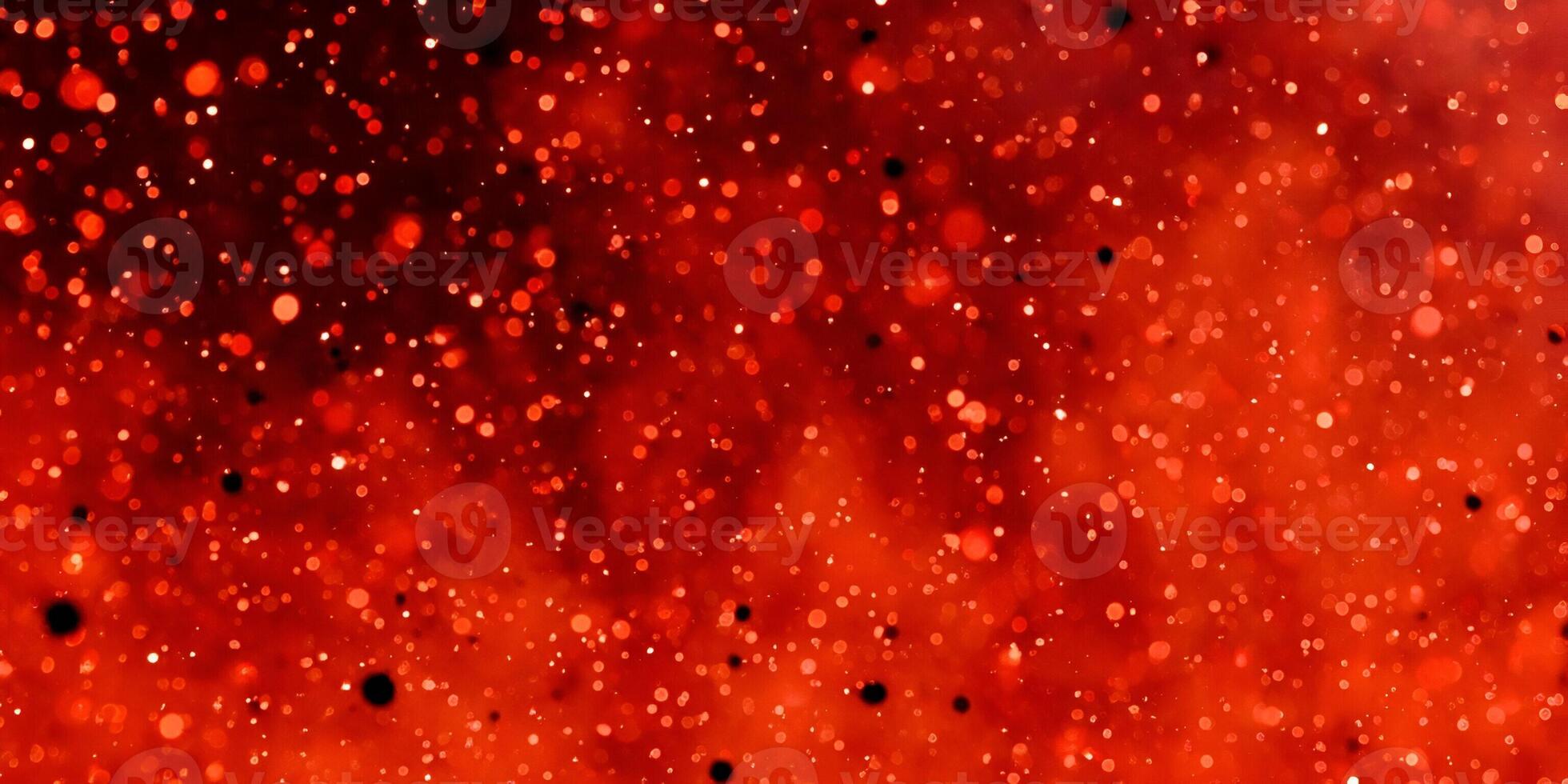 A vibrant red bokeh background with shimmering light particles creates a magical and festive abstract texture photo