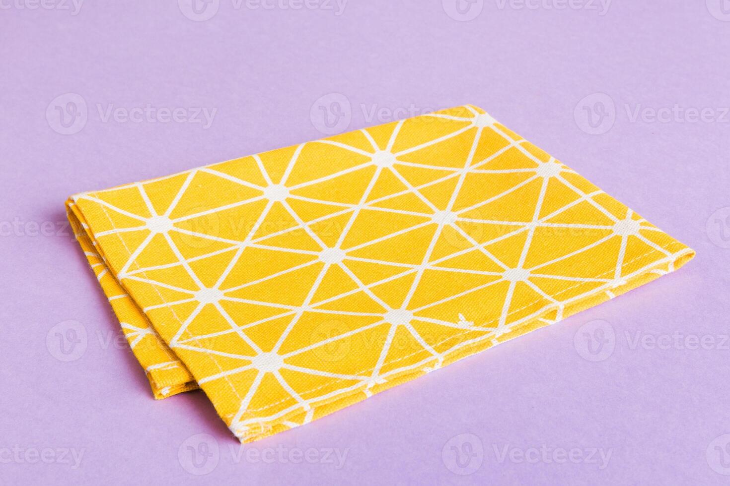 top view with yellow empty kitchen napkin isolated on table background. Folded cloth for mockup with copy space,Minimal style photo