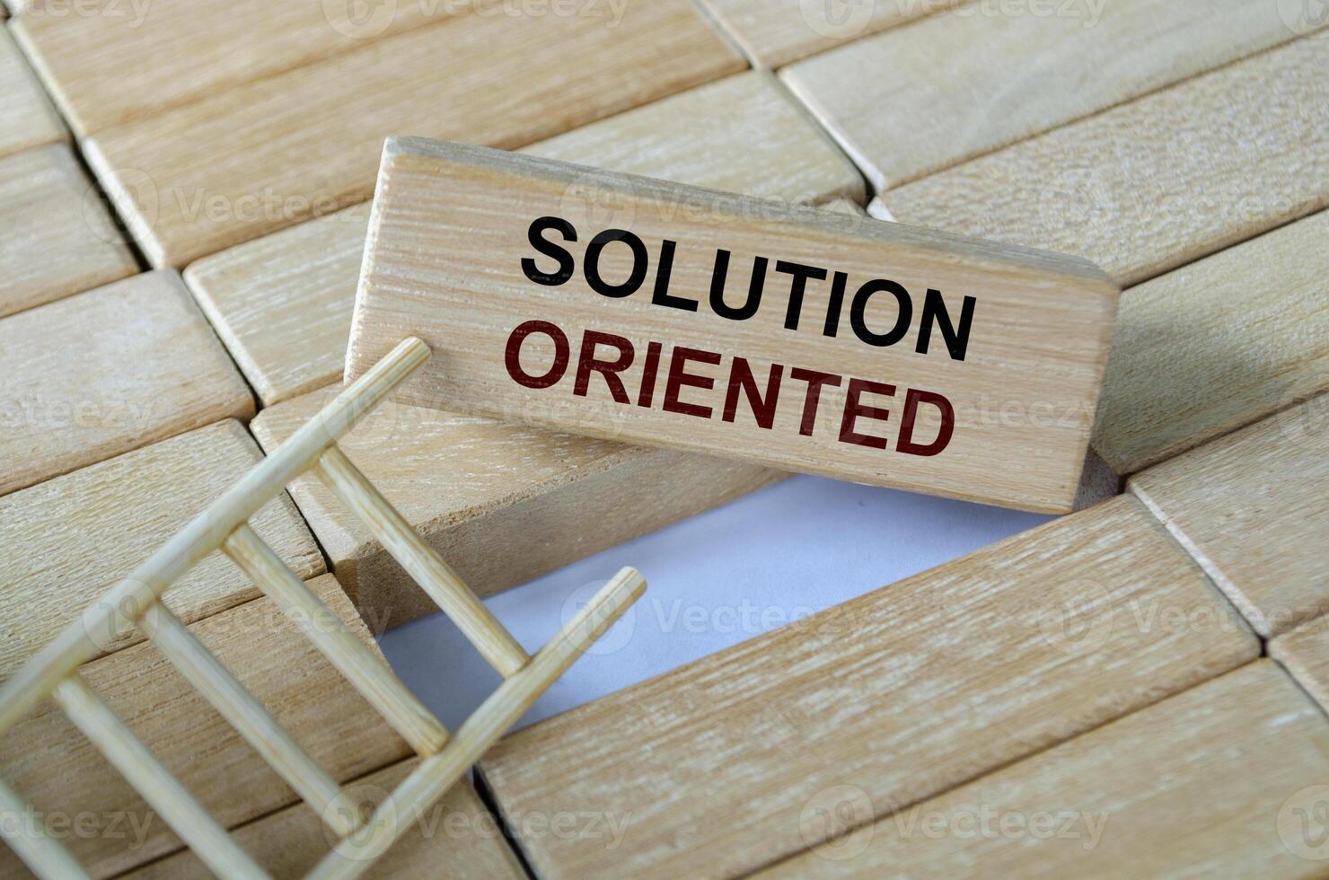 Solution oriented text written on wooden blocks set on a ladder symbolizing problem-solving strategies and adaptability. photo