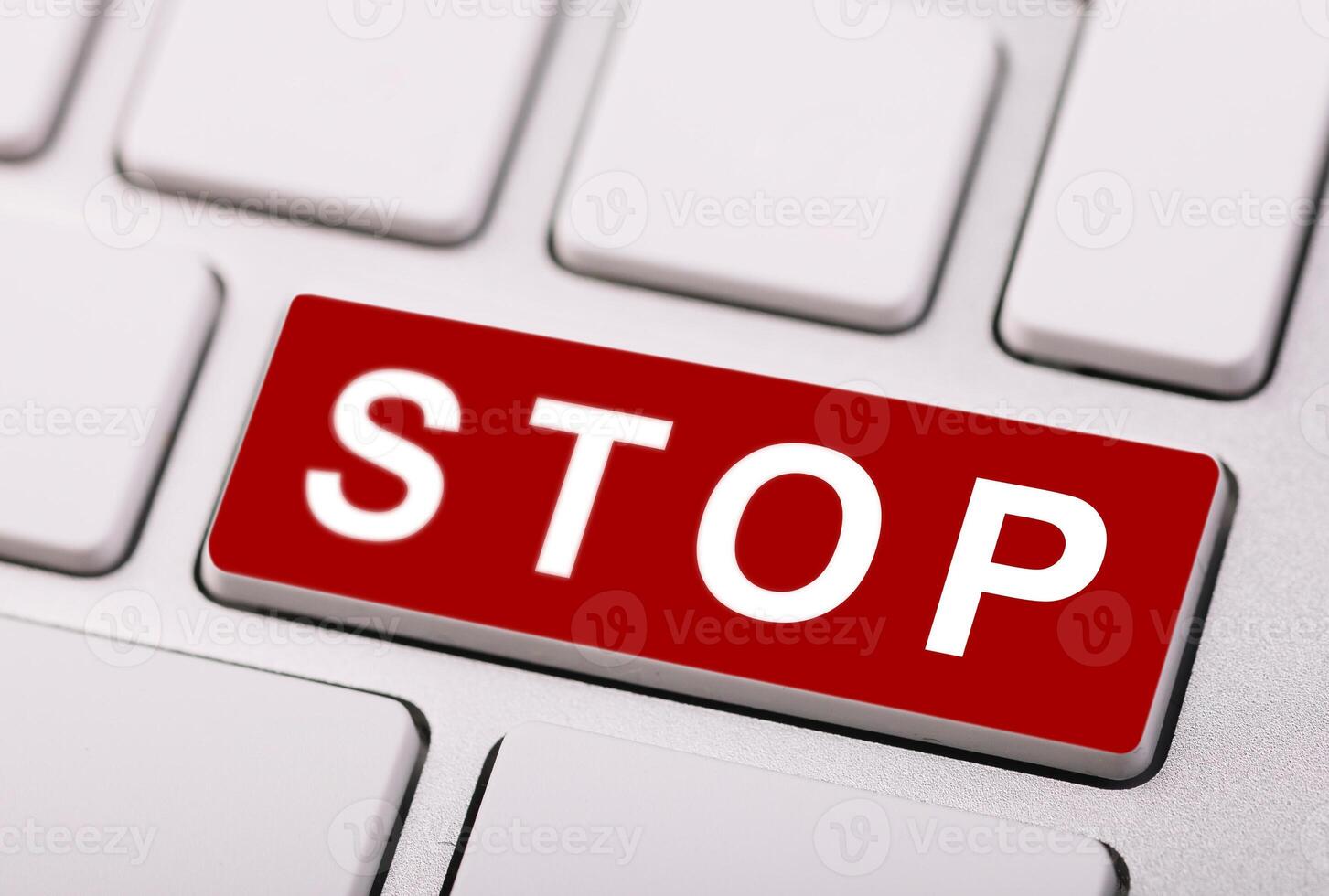 Close-up of a red STOP button on a computer keyboard, symbolizing caution, warning, or security alert in digital contexts. photo