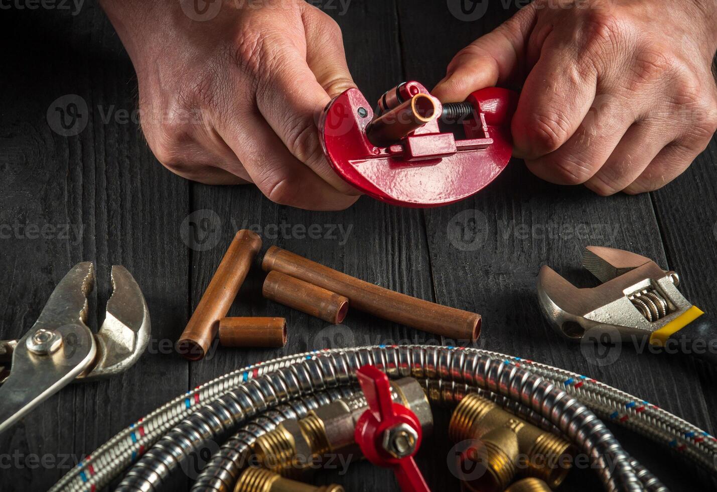 Master plumber cuts copper pipes to install a gas pipeline. Close-up of the hands of the master while working in the workshop photo