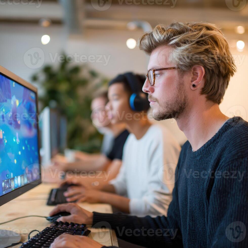 Focused team of young adult developer professionals testing new game. men work with intense concentration on computer in modern creative office photo