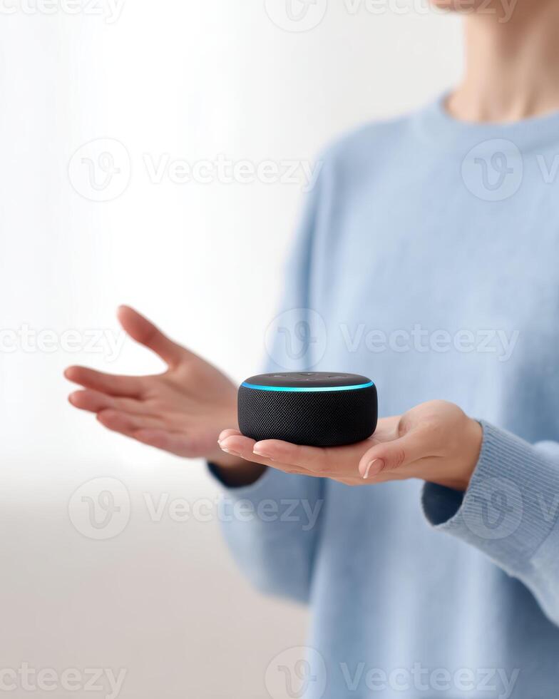 Focused woman holding smart speaker in hand. modern smart home device using voice assistant technology for convenient control and automation in home setting photo