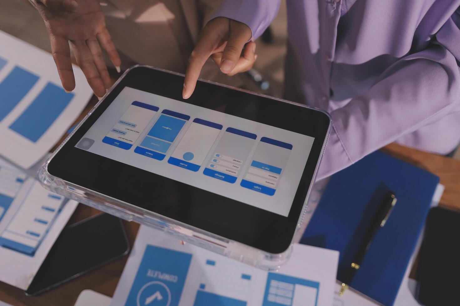 Hands showing UI design on tablet photo