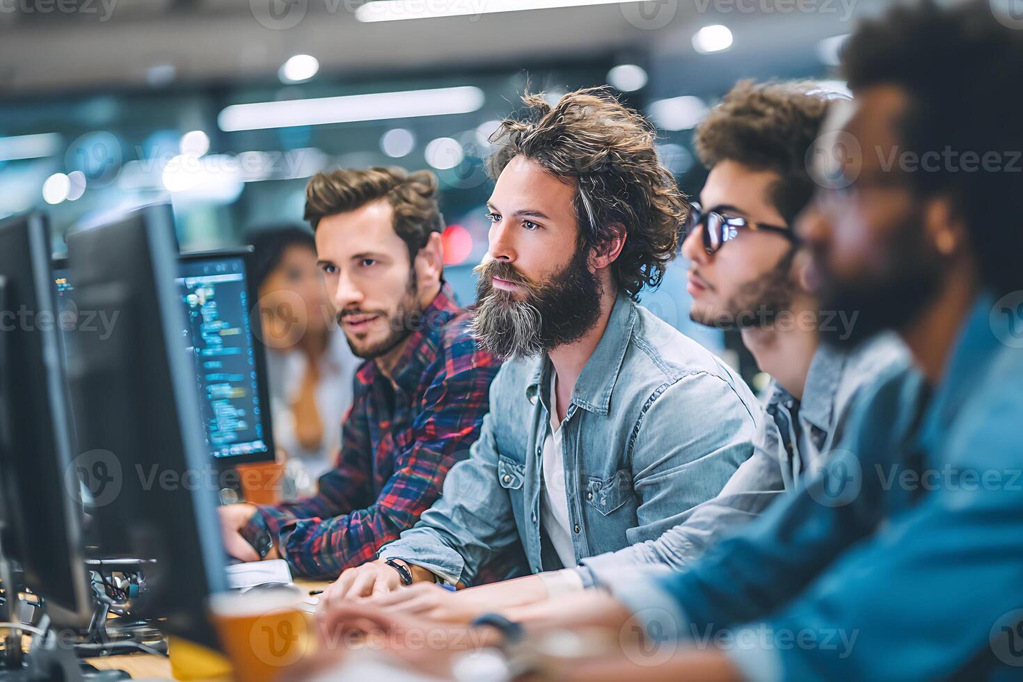 Bearded programmer with his diverse team of developers working intently in a modern office. photo