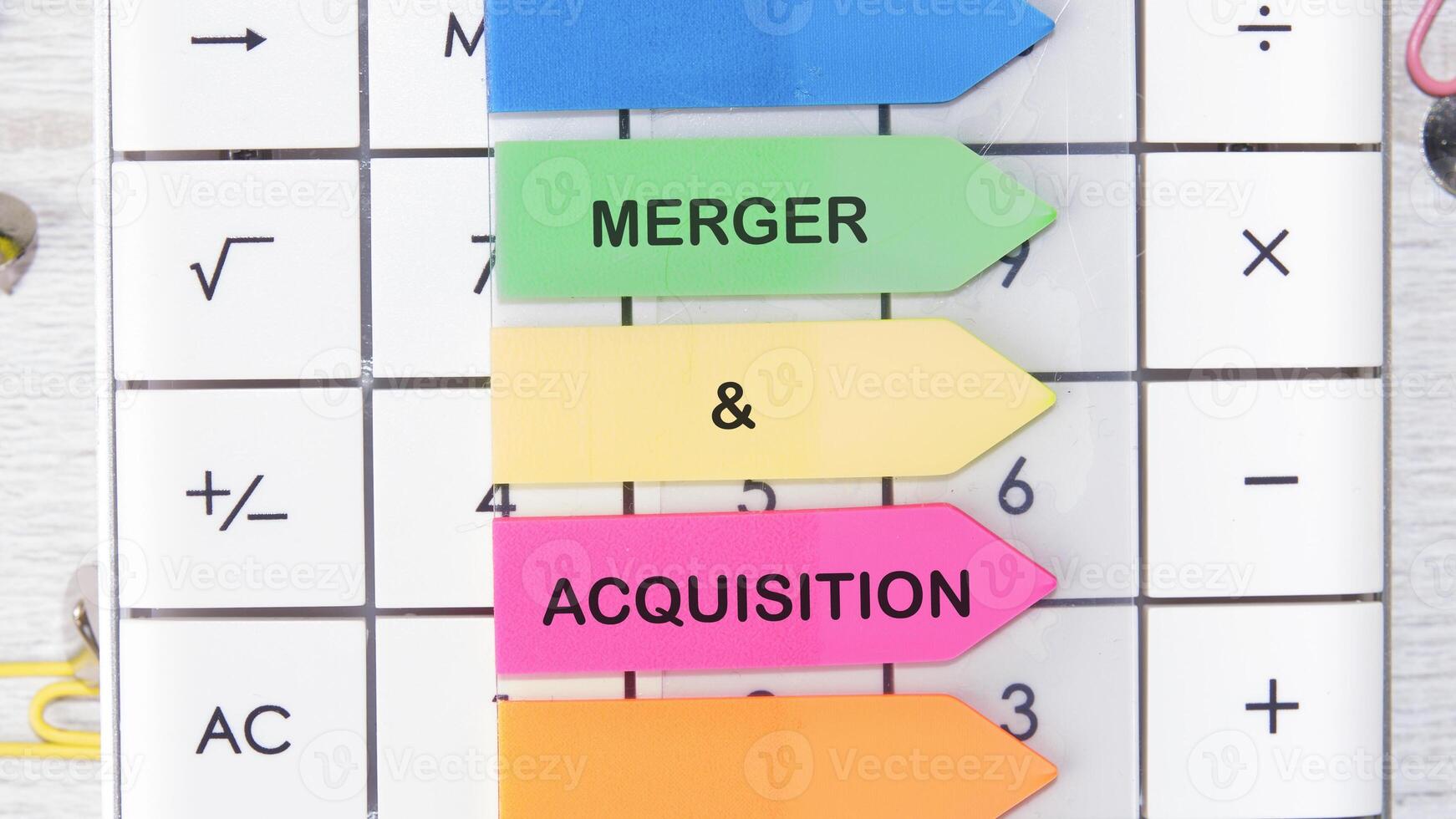 Merger and Acquisition Icon and Global Network with Analyzing Technological Data. MERGER and ACQUISITION written on a sticker on the background of the calculator photo