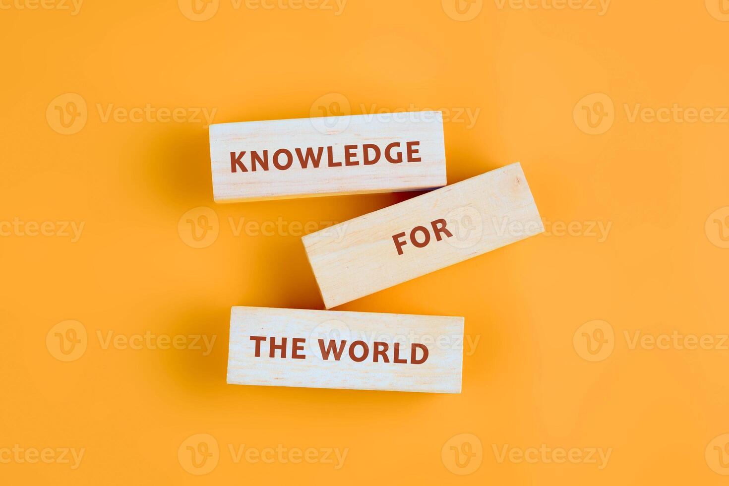 Concepts of business organizations and industries. KNOWLEDGE FOR THE WORLD assembled from blocks on orange background, top view photo