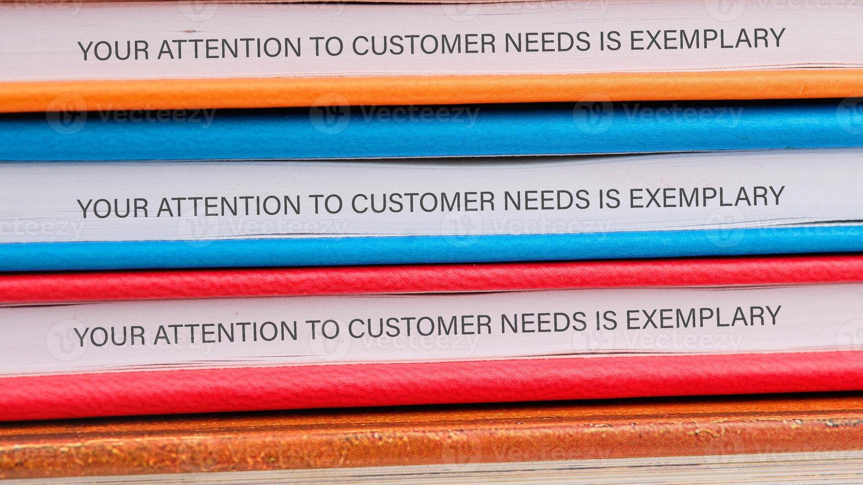 A stack of colorful binders displays the phrase, demonstrating a commitment to customer service excellence. This emphasizes the importance of meeting client needs effectively photo