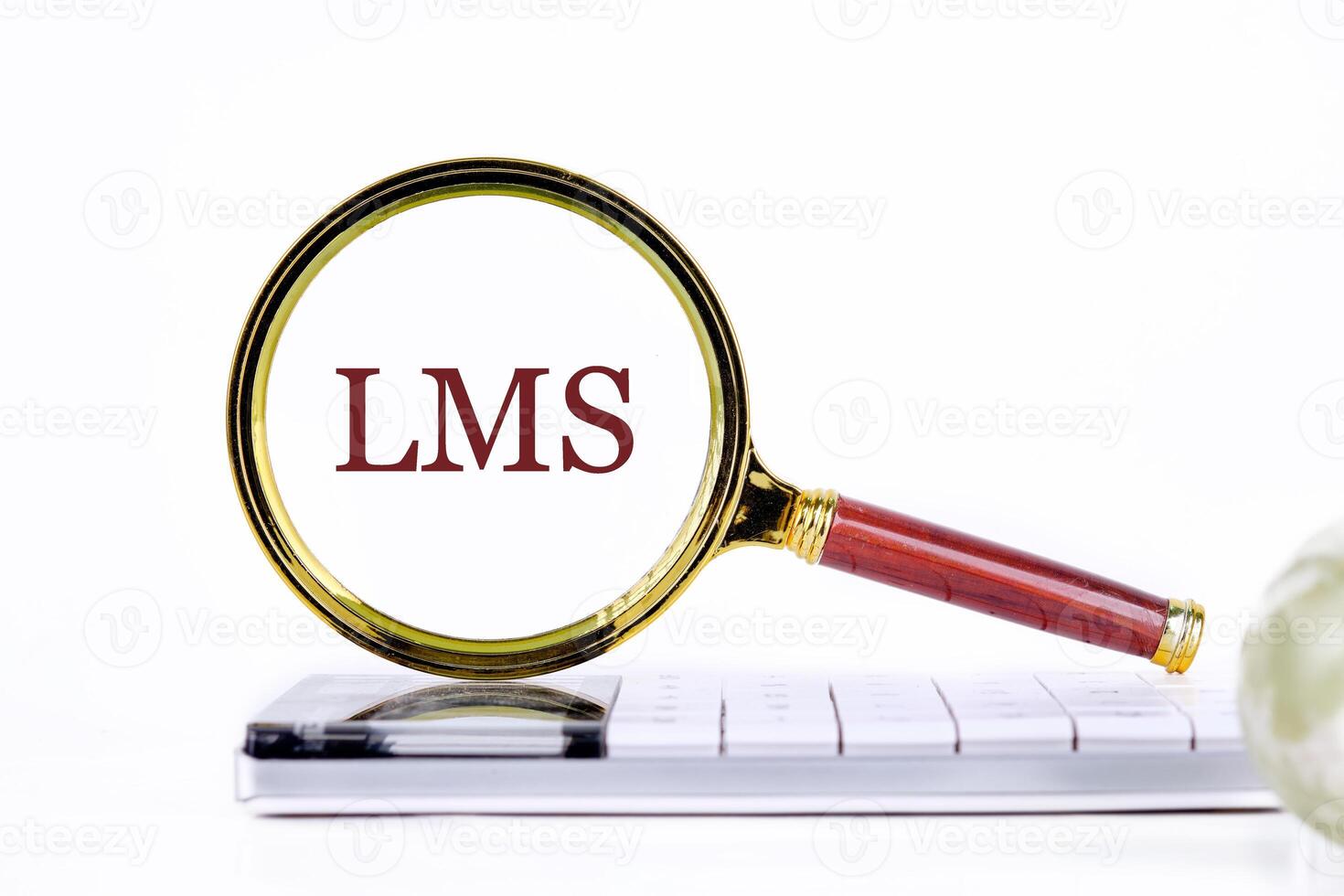 Abbreviation of Learning management system, Word LMS writing through a magnifying glass on a calculator on a light background. Business development concept photo
