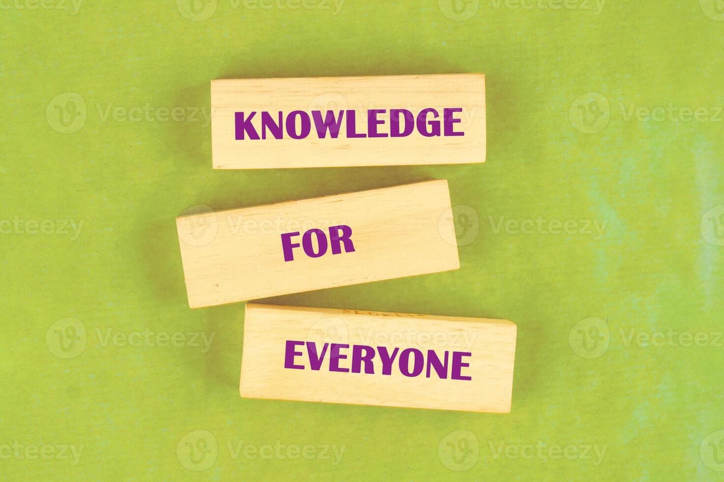 Learning for Everyone concept. Words KNOWLEDGE FOR EVERYONE assembled from blocks on a light green background, top view photo