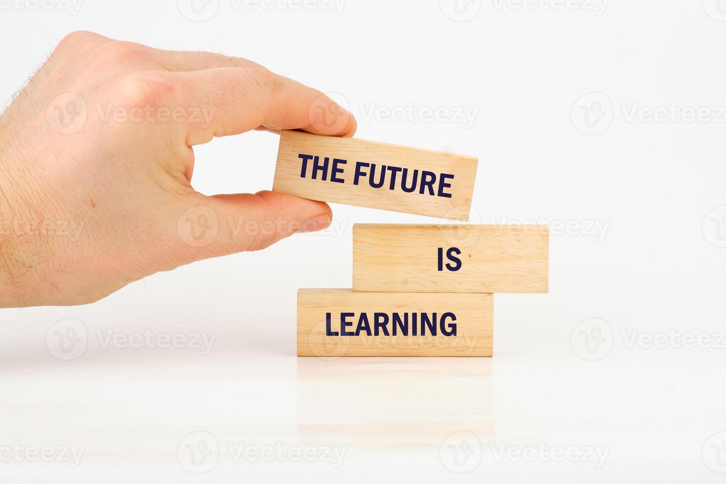 Concept of Intelligence, science and mind. THE FUTURE IS LEARNING made from blocks with hand on white background photo