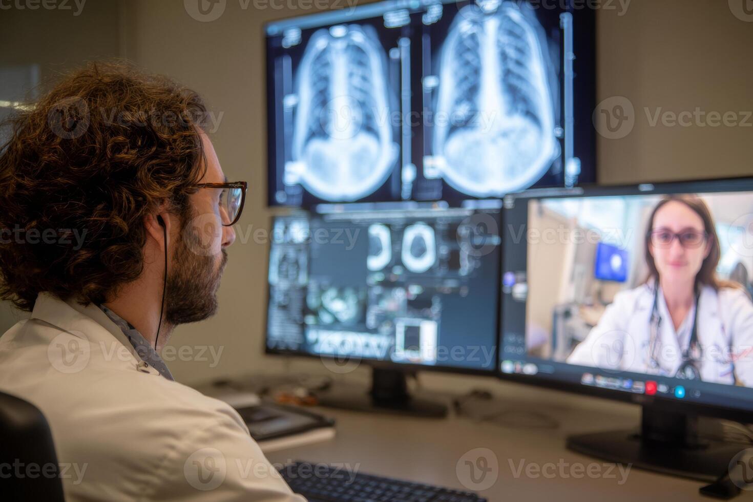 Radiologist engages in a virtual consultation with a patient, analyzing CT images displayed on dual screens in a contemporary medical setting. High definition resolution captures the details clearly photo