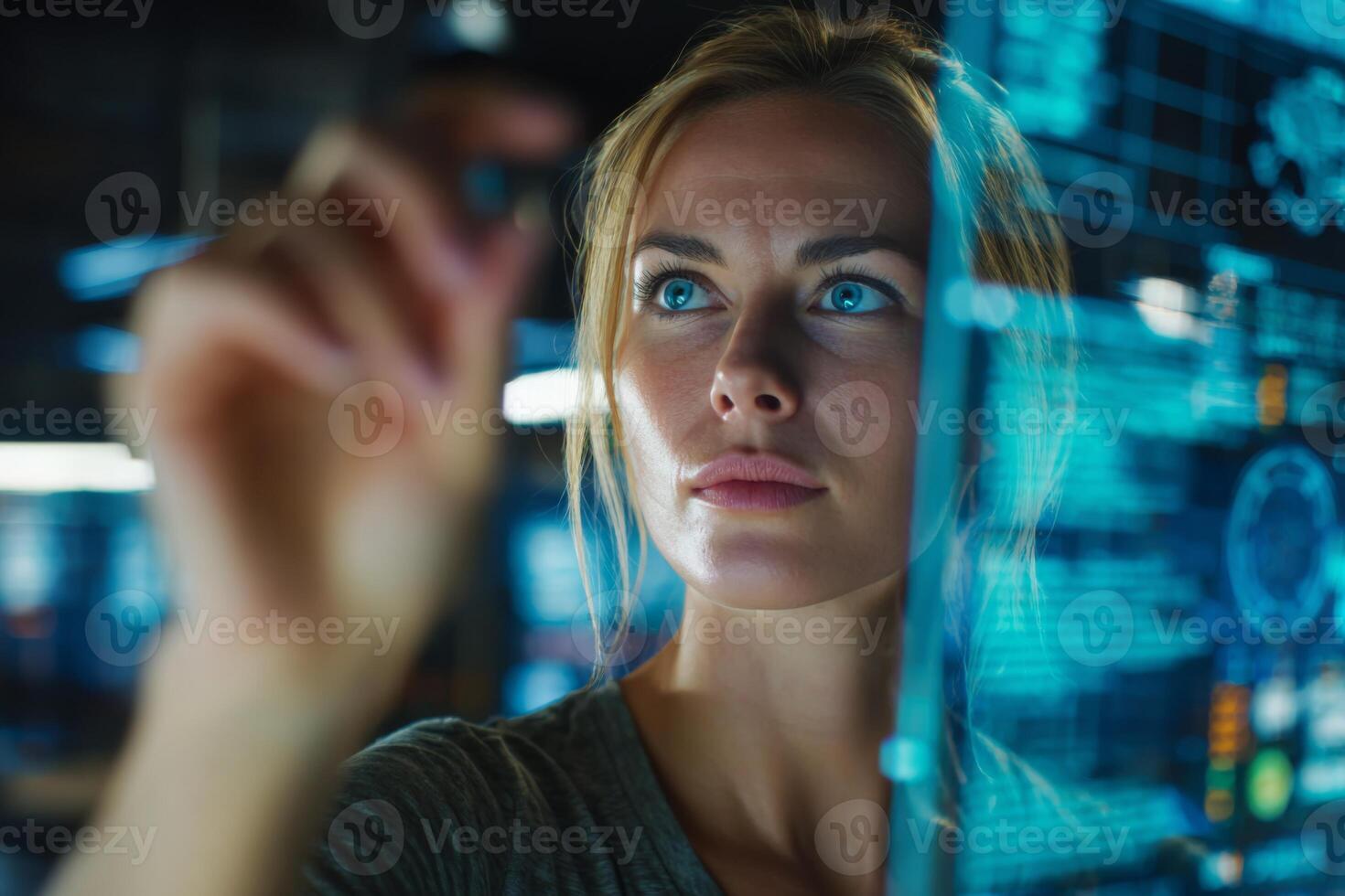 A woman interacts with a glowing touchscreen display, focusing on digital data and graphs in a modern setting. The atmosphere suggests advanced technology and innovation photo