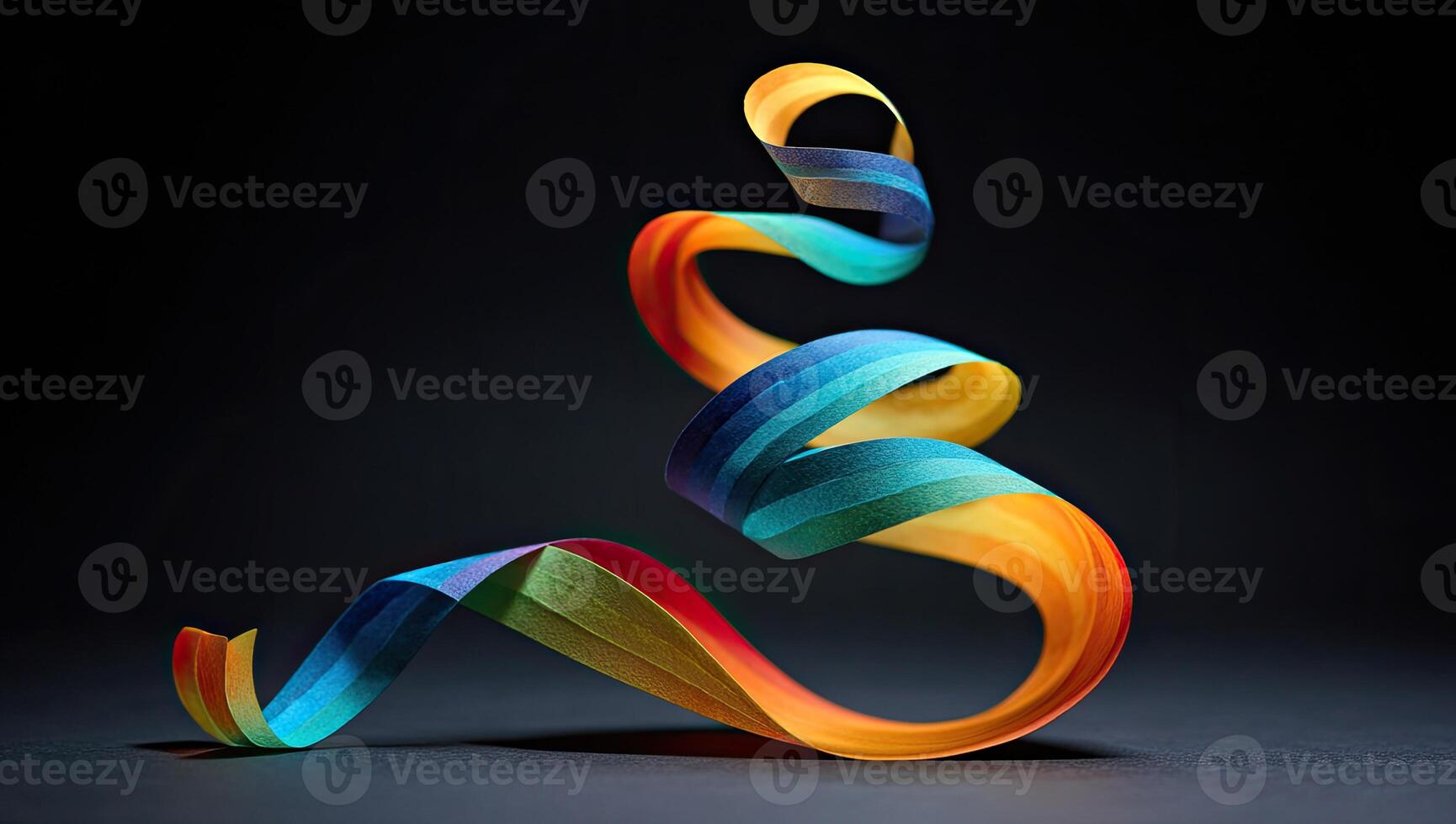 A colorful paper ribbon curls elegantly against a dark background, creating a whimsical shape photo