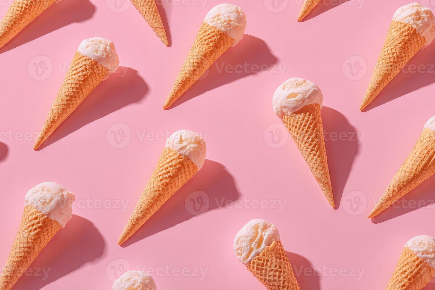 Overhead shot of a repeating pattern of ice cream cones on a pink background photo