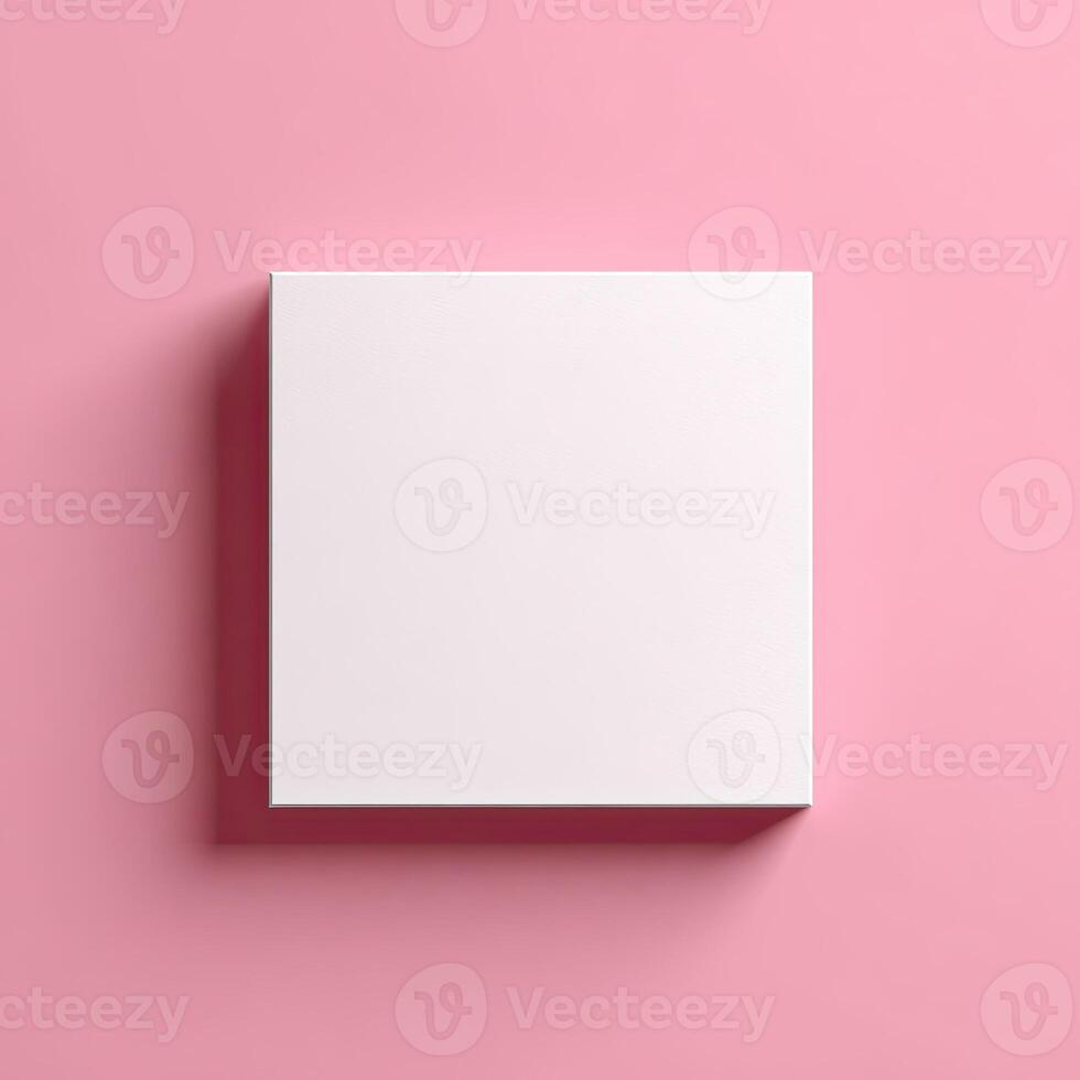 A top-down view of a square, white box casting a shadow on a smooth, pink surface photo